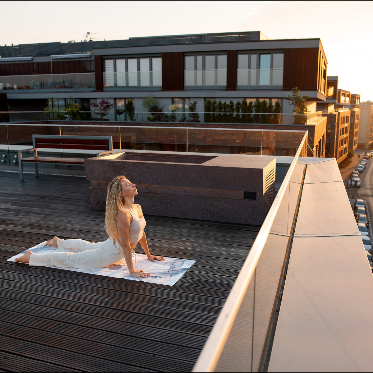 Woman relaxing on a rooftop deck beside a Loki Porfido Marrone cold plunge