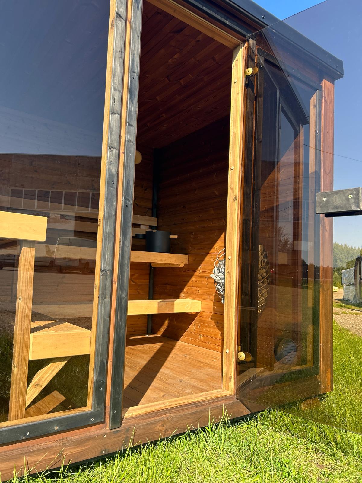 Grand Monarch Traditional Outdoor Sauna on a field Front view with its door open Close up