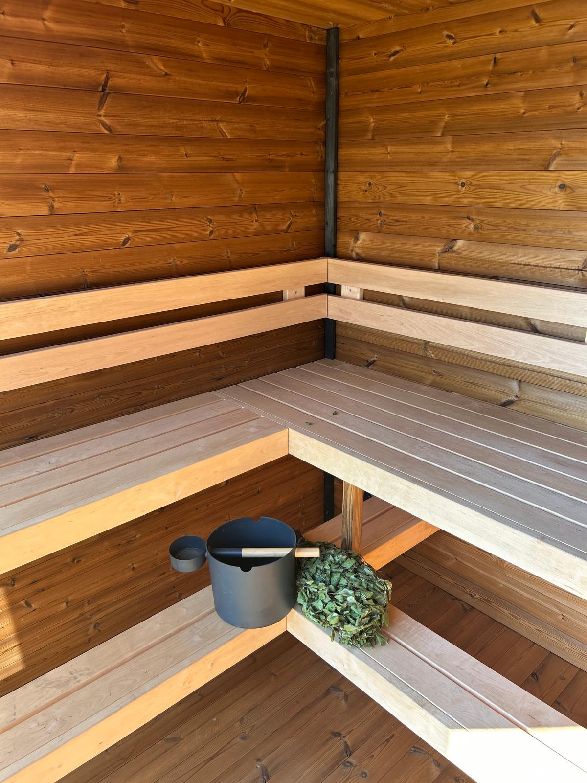 Grand Monarch Traditional Outdoor Sauna Interior view with a bucket laddle termometer