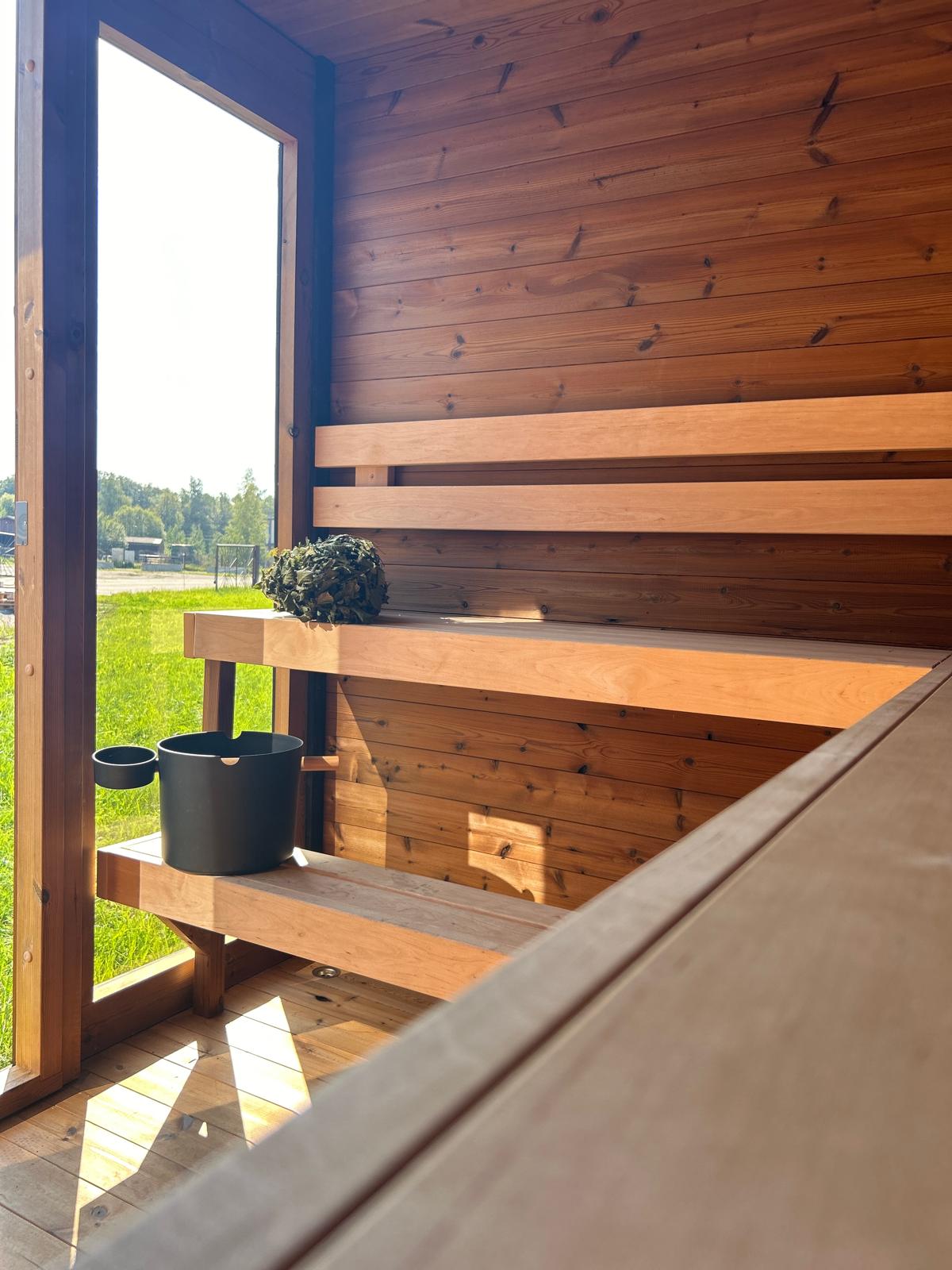 Grand Monarch Traditional Outdoor Sauna Interior view with a bucket laddle termometer looking outside through the front window
