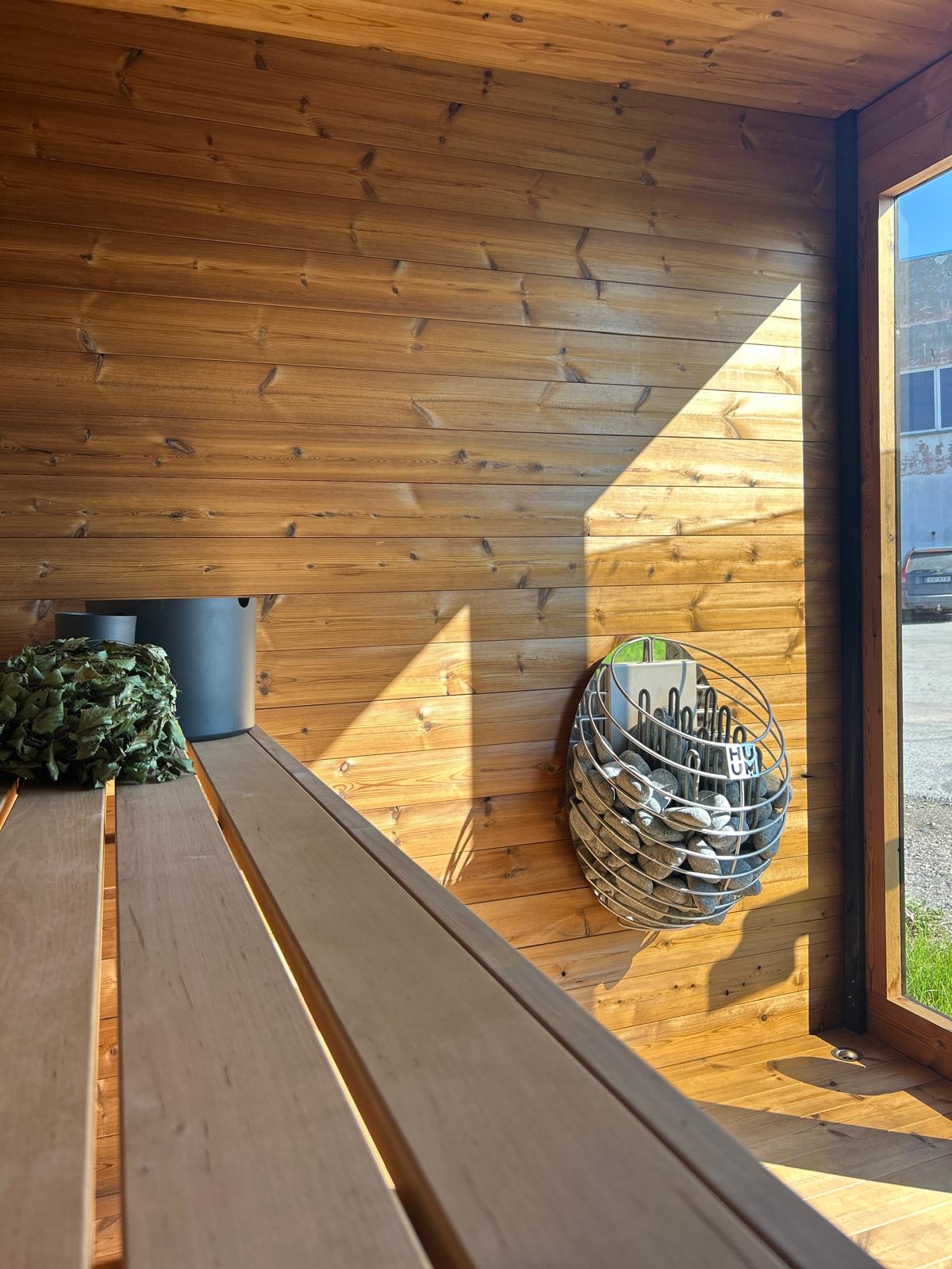 Grand Monarch Traditional Outdoor Sauna Interior view with a bucket laddle termometer and heather