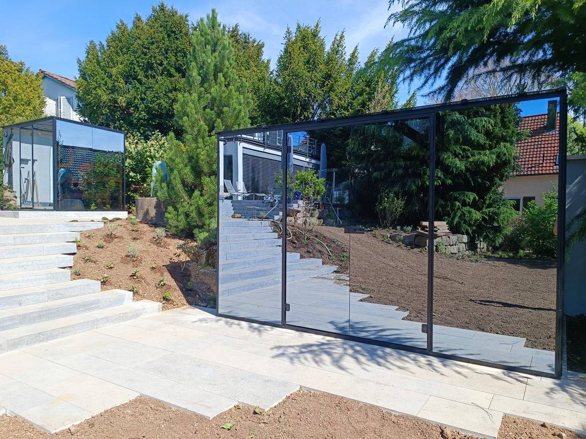 Mirrored glass cabin in a landscaped garden