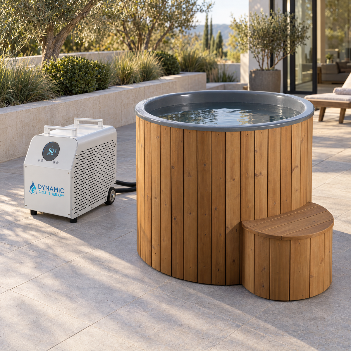 Outdoor hot tub with a wood-look wrap and a small matching bench, shown beside a white pump unit on a patio. The hot tub is filled with water and the pump is branded DYNAMIC.